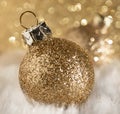 Gold glittering Christmas bauble with a defocused bokeh background and a shallow depth of field Royalty Free Stock Photo