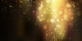 Gold glittering sparkle stardust on black background with bokeh lights Royalty Free Stock Photo