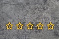 Gold, gray, silver five stars shape on the gray concrete background. Concept image of setting a five star goal. Increase rating or Royalty Free Stock Photo