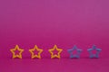 Gold, gray, silver five stars shape on a purple background. Increase rating or ranking, evaluation and classification idea. Three Royalty Free Stock Photo