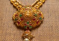 Gold Guttapusalu Necklace with gemstones a traditional Indian wedding jewelry on wooden textured background