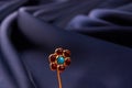 Gold hairpin with ruby precious stone on blue silk background