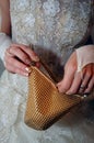 Gold handbag in bride hands