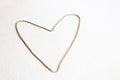 A gold heart is made of chain, symbol of love on a white textural background at the left side