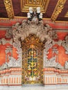 A gold-incrustated door at an inner court of a private house on Bali island in Indonesia