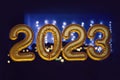 Gold inflatable foil balloons numbers 2023 on the window against the background the night city, in neon light. New year Royalty Free Stock Photo