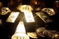 Gold ingot and bitcoin against black background