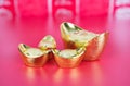 Gold ingot ornaments on red background Royalty Free Stock Photo