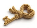 Gold key embellished with a knitted loop isolated on white background Royalty Free Stock Photo