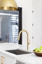 A gold kitchen faucet detail in a white kitchen. Royalty Free Stock Photo
