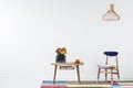 Gold lamp above wooden chair next to table with flowers in folk