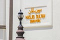 Gold  lettering by arabic script and malay on white wall at front of entrance of Masjid Sultan Mosque Singapore. Royalty Free Stock Photo