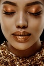 Gold Luxury black skin woman African Ethnic female face. Young african american model with jewelry Royalty Free Stock Photo