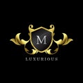 Gold Luxury Shield M Letter Logo. Elegance logo vector template made of wide silver alphabet font on shield frame ornate luxury