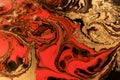 Gold marbling texture design. Red and golden marble pattern. Fluid art.