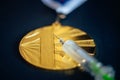 Gold medal and syringe. Doping and drugs in sport, concept photo. Black background