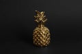 Gold metal decorative pineapple on black