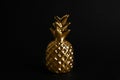 Gold metal decorative pineapple on black