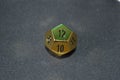 Gold metallic d12 twelve sided dice on foam surface