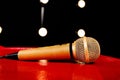 Gold microphone on dark background with many lights Royalty Free Stock Photo