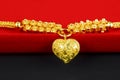 The Gold necklace and heart shape pendant and gold ring on red velvet box Royalty Free Stock Photo