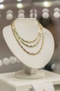 Gold necklace on the showcase. vertical photo