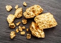 Gold nuggets on black stone background top view. Imitation of gold nuggets Royalty Free Stock Photo