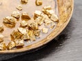 Gold nuggets on brass plate top view. Imitation of gold nuggets Royalty Free Stock Photo