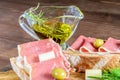 Gold olive oil in the glass transparent bowl, sliced fresh ham and cheese with ham closeup. Healthy food ready to eat