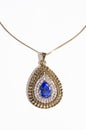 Gold pendant with blue gem on a white background Royalty Free Stock Photo