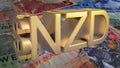 Gold-plated NZD dollar symbol on the background of New Zealand banknotes. Finance concept.