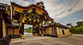 Gold plated wooden Japanese entrance gate to the inner gardens of the Kyoto Nijo Castle. Panoramic view from outside the wall