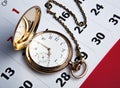 Gold pocket watch and a wall calendar Royalty Free Stock Photo