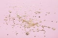 Gold potal drops and splashes on pale pink paper. Creative background