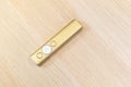 Gold presentation remote control with arrow slide changing buttons, object laying on a wooden table, closeup, top view, nobody Royalty Free Stock Photo
