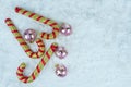 Gold and red candy canes with glitter Christmas baubles on the snow. Royalty Free Stock Photo