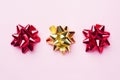 Gold and red Christmas bows on pink background. Gift concept greetings for holidays birthday Wedding New year Christmas mother`s