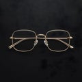 Gold rimmed glasses create striking contrast against black background