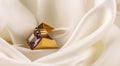 Gold ring with alexandrite on the background white silk