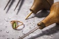 Gold ring with precious stones on the table, surrounded by jewelry repair tools