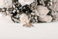 Gold ring and Soft focus rose flower bouquet . Wedding horizontal copy space beige light background Royalty Free Stock Photo