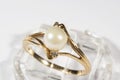A gold ring with a white round pearl and two small diamonds Royalty Free Stock Photo