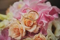 gold rings and a beautiful bridal bouquet of roses on the background. details  wedding traditions. close-up  macro Royalty Free Stock Photo