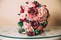 The gold rings of the newlyweds and the groom`s boutonniere lie on a wooden vintage table. A wedding bouquet of red and Royalty Free Stock Photo