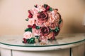 The gold rings of the newlyweds and the groom`s boutonniere lie on a wooden vintage table. A wedding bouquet of red and Royalty Free Stock Photo