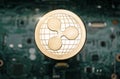 Gold Ripple coin, on background of computer motherboard