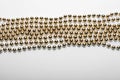 Gold round beads garland on white backgroun. Flat lay. Top view