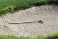 Gold sand rake laying in a bunker