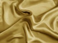 Gold shiny silk. Wavy fabric background