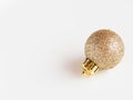 Detail of a shiny and flashy glitter gold christmas ornament on white background